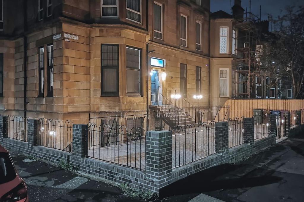 un bâtiment avec une clôture devant lui dans l'établissement S.H Apartments, à Glasgow