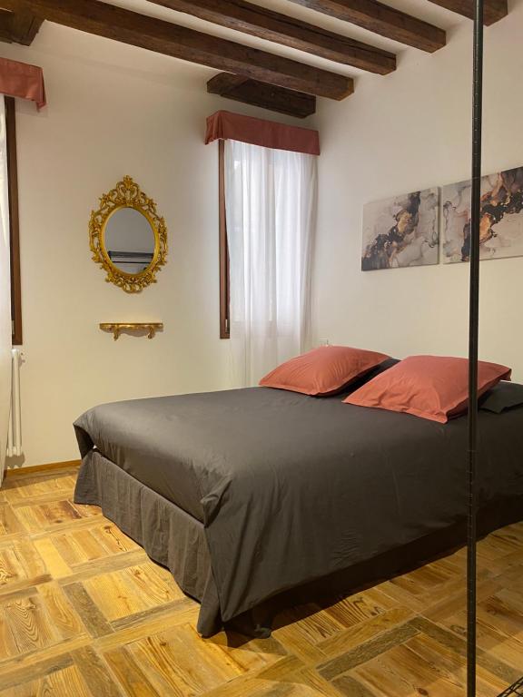 1 dormitorio con cama y espejo en la pared en Ca' degli Specchieri - A due passi da Piazza San Marco en Venecia