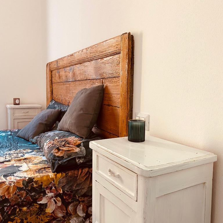 een slaapkamer met een bed met een houten hoofdeinde bij Appartamento Casaliva sul Garda in Pulciano