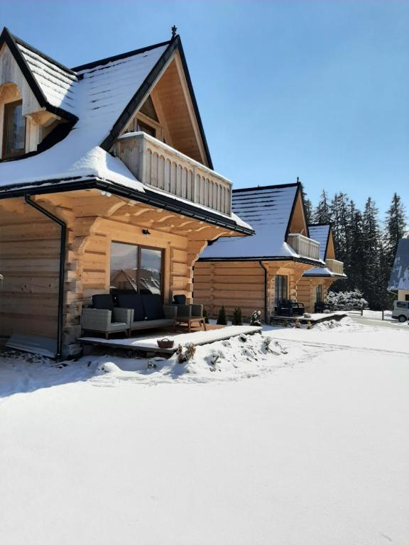 a log home with snow on the ground at Domki Malcykówka z własnym Jacuzzi - w cenie in Ząb