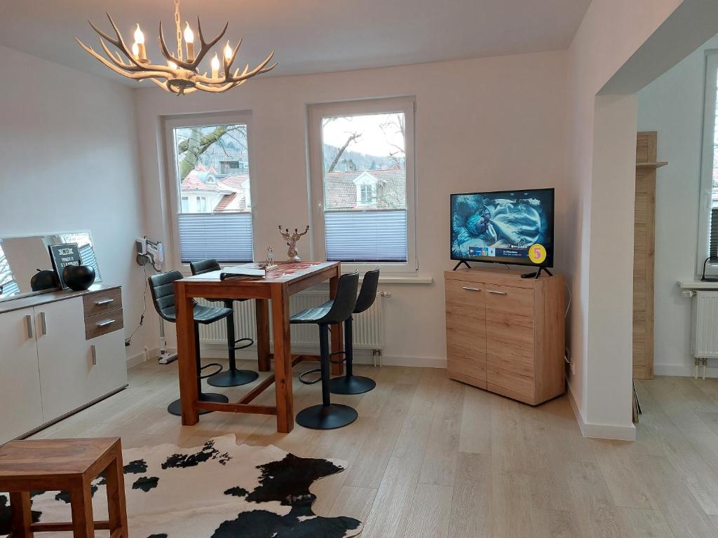 a living room with a dining room table and a television at Ferienwohnung am Jungbrunnen 2 in Bad Harzburg