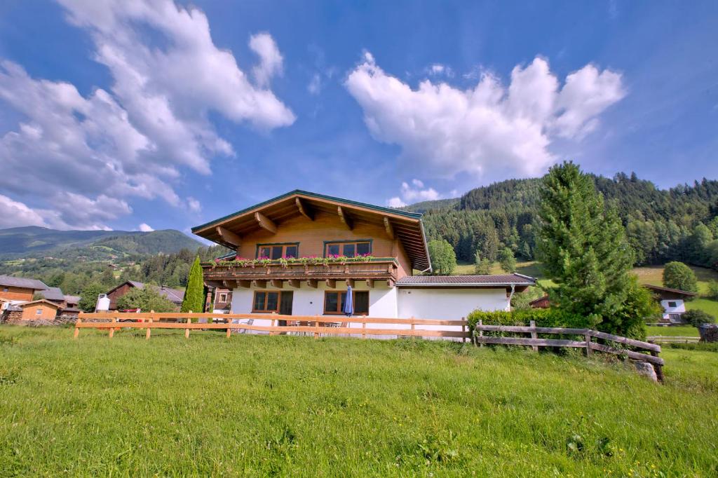 dom na wzgórzu na zielonym polu w obiekcie Chalet Dorfkristall w mieście Bramberg am Wildkogel