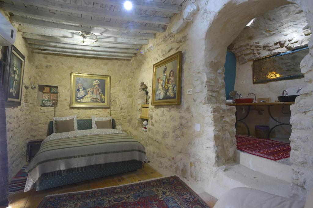 ein Schlafzimmer mit einem Bett in einer Steinmauer in der Unterkunft Auberge de Tamezret in Tāmazrat