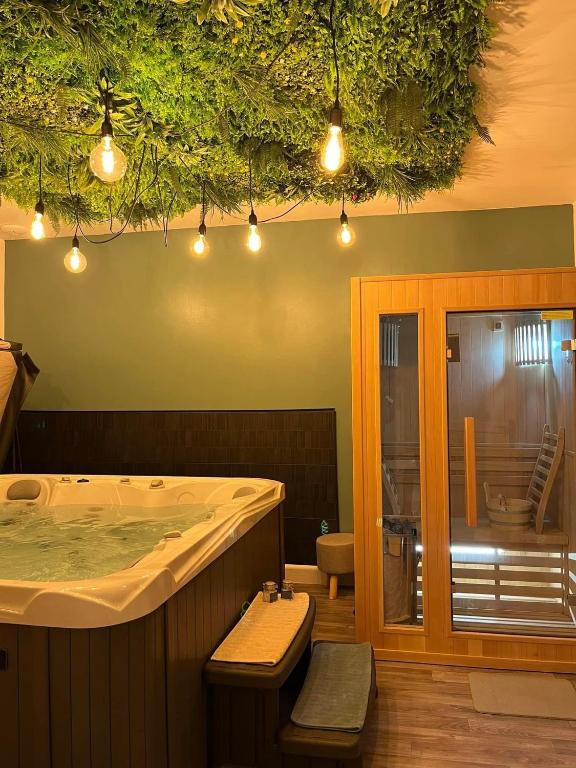 - une grande baignoire dans une chambre avec une table et des chaises dans l'établissement Bleu Horizon, à Quiberville