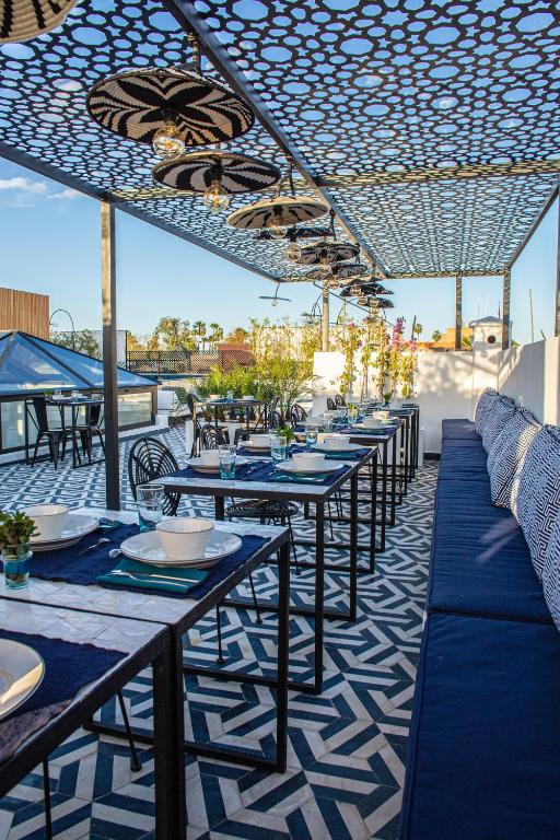 a row of tables on a patio with blue and white at Le Pavillon de la Kasbah & SPA Marrakech in Marrakesh