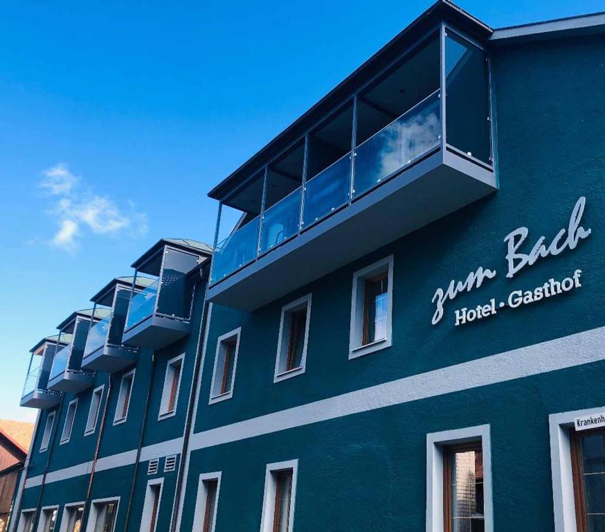 ein blaues Gebäude mit Balkon darüber in der Unterkunft Hotel-Gasthof zum Bach in Neukirchen beim Heiligen Blut