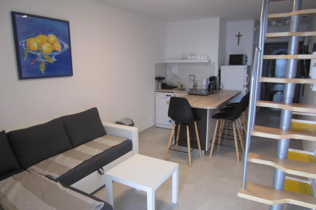 a living room with a couch and a kitchen at Apartman Valinor in Miholašćica