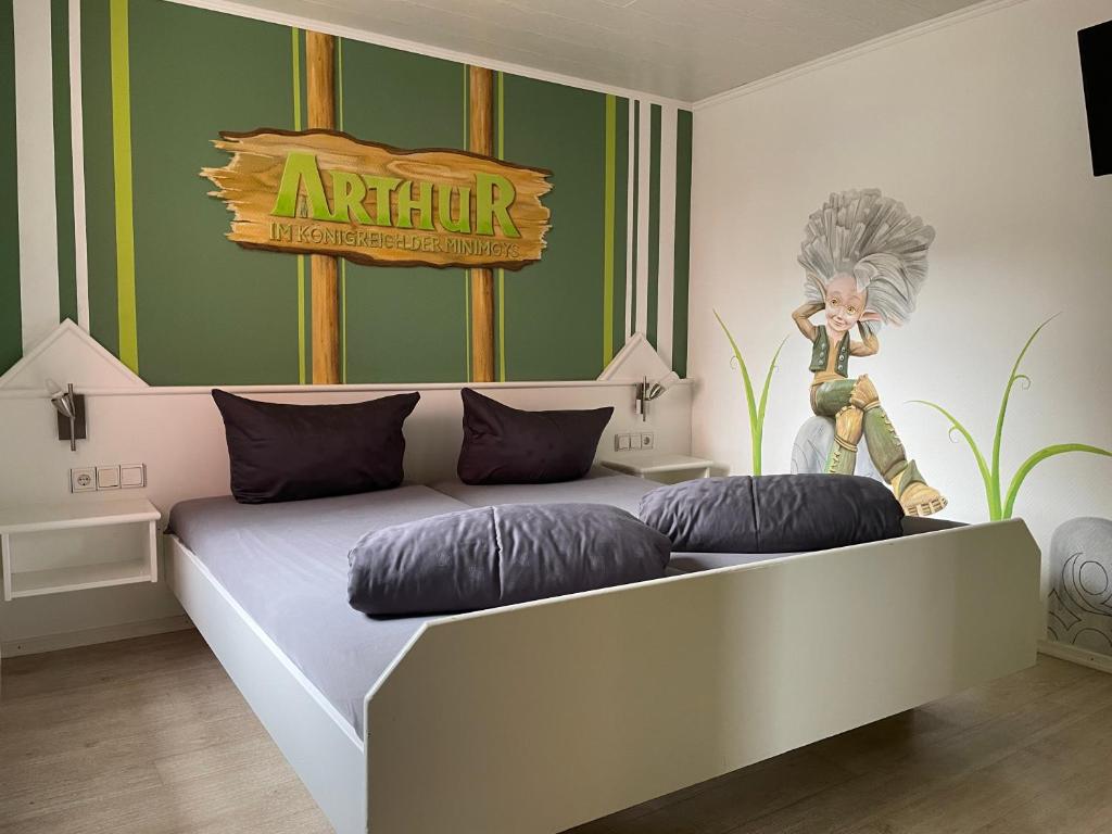 a bedroom with a large bed with a sign on the wall at PENSION JÄGER - der Geheimtipp am Europa-Park in Rust