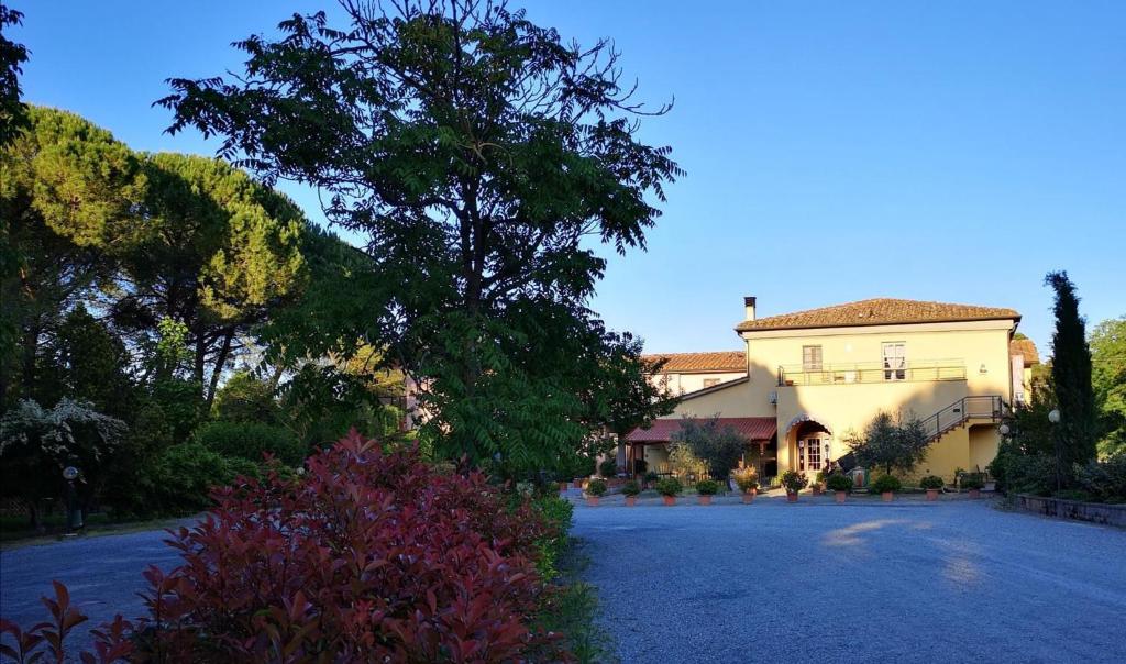 ein großes Haus mit einer Einfahrt davor in der Unterkunft Hotel Molino D'Era in Volterra