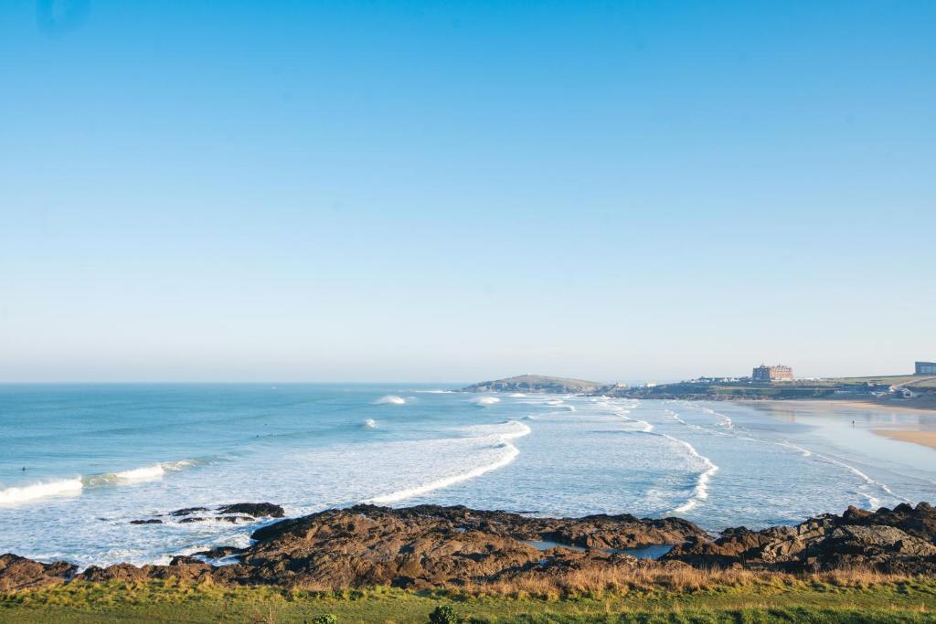 a view of a beach with rocks and the ocean at Fistral Beach Hotel and Spa - Adults Only in Newquay