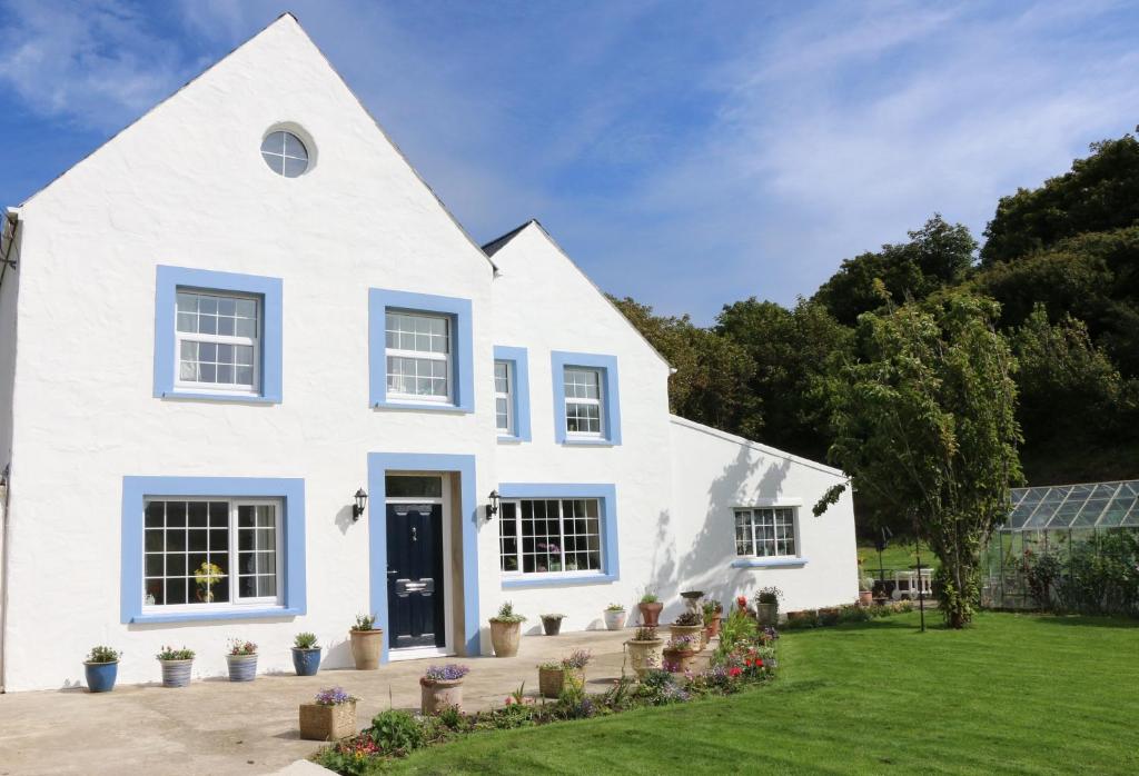 una casa blanca con una puerta azul en Ty Nant Little Haven, en Little Haven