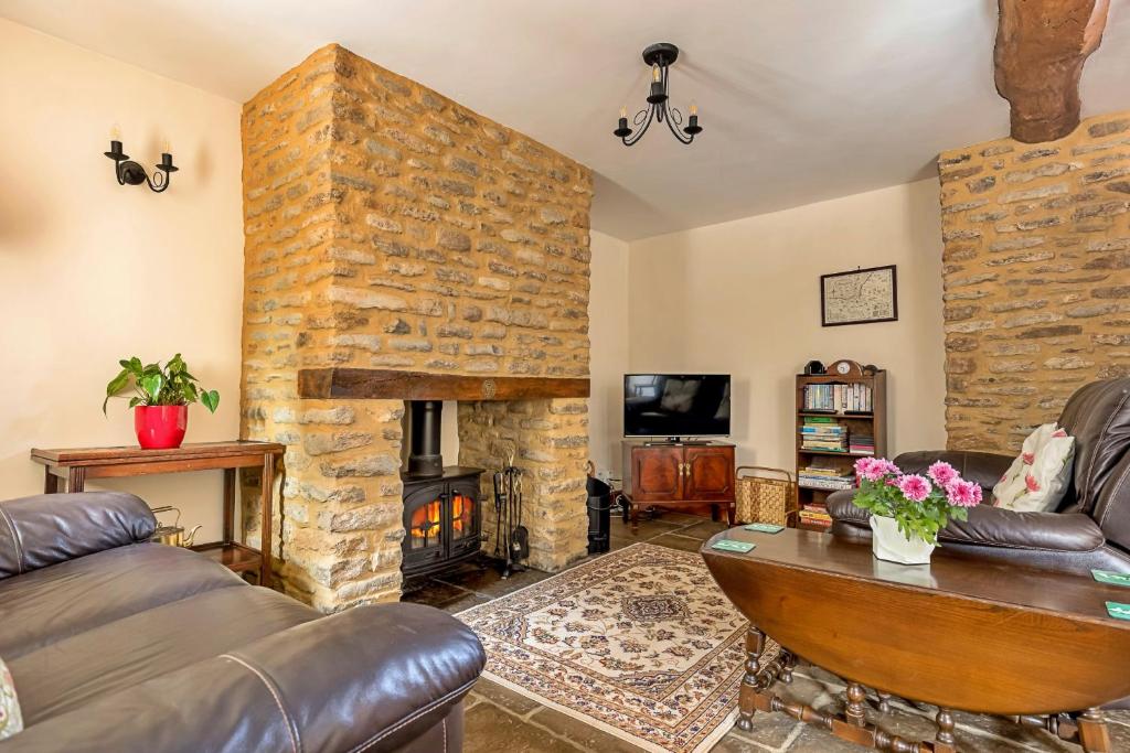 a living room with a large stone fireplace at Finest Retreats - Fives Court Cottage in North Cheriton