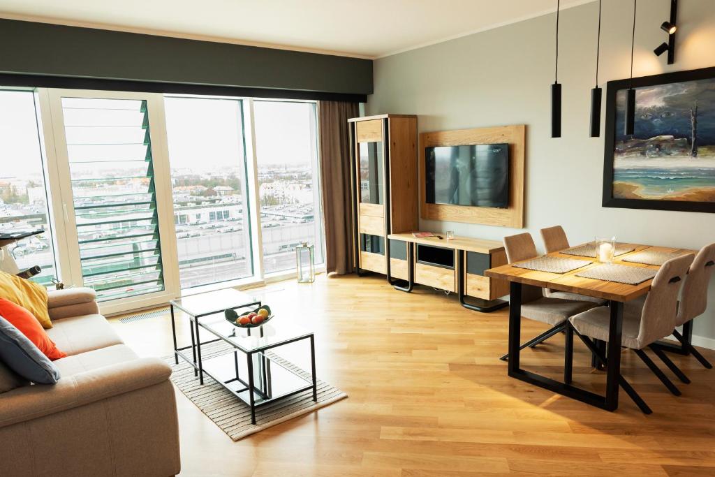 un soggiorno con tavolo e TV di Capital Apartments Panorama a Poznań