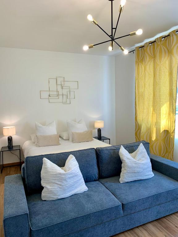 - un salon avec un canapé bleu et un lit dans l'établissement DIJON CENTRE VILLE : SUPER APPARTEMENT NEUF, à Dijon