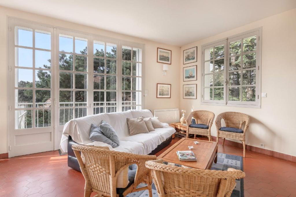 un salon avec un canapé, des chaises et des fenêtres dans l'établissement Villa à Pornic à 100m de la Plage, à Pornic