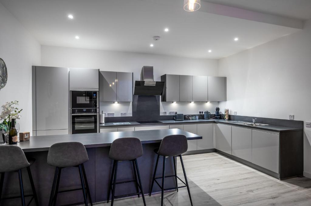 a kitchen with a counter and stools in it at Casa Fresa - Seamen's Chapel in Dundee