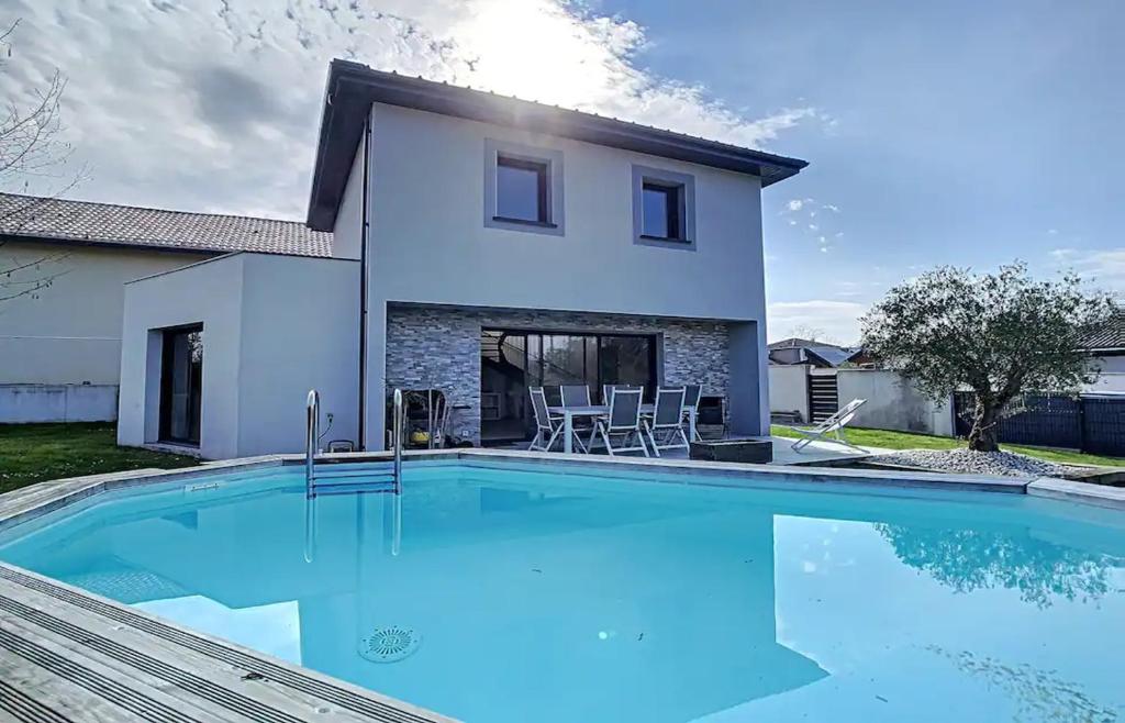 una villa con piscina di fronte a una casa di Les Arènes a Dax