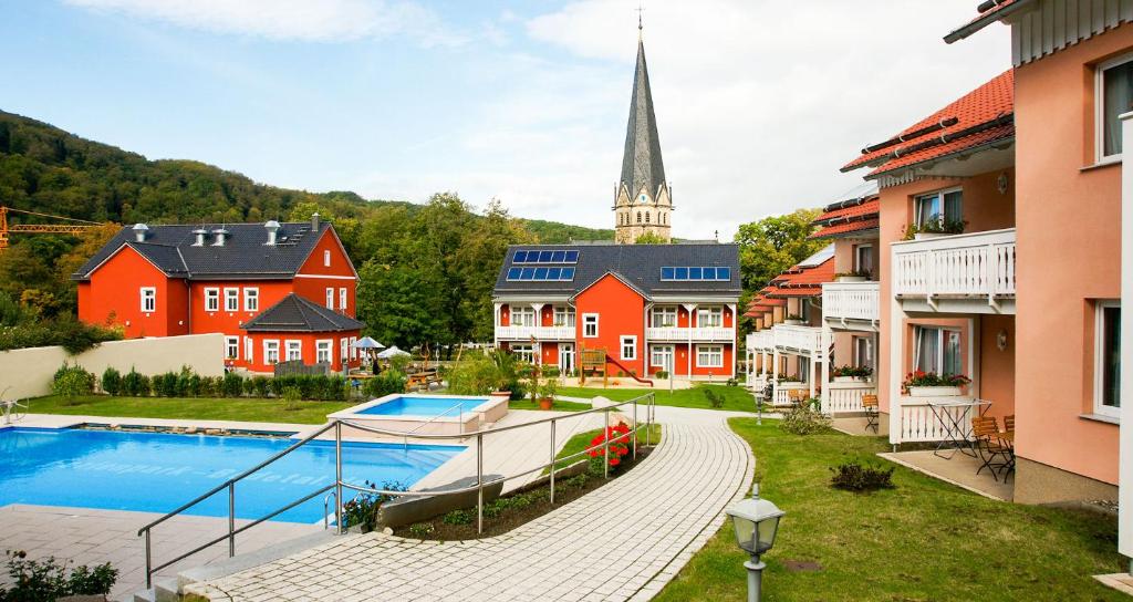 a group of buildings with a church in the background at Hotelpark Bodetal mit Ferienwohnungen in Thale