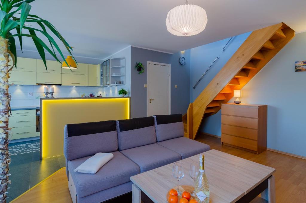 a living room with a couch and a table at Holiday Home Neptun 12 dwupoziomowy, 2 łazienki, 2 sypialnie, balkon in Międzyzdroje