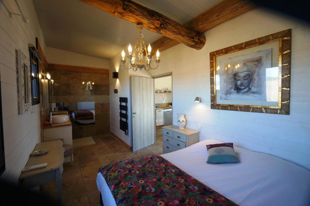 een slaapkamer met een groot bed en een badkamer bij Gîtes Equestres Lou Caloun - Les Saintes Maries de la Mer in Saintes-Maries-de-la-Mer