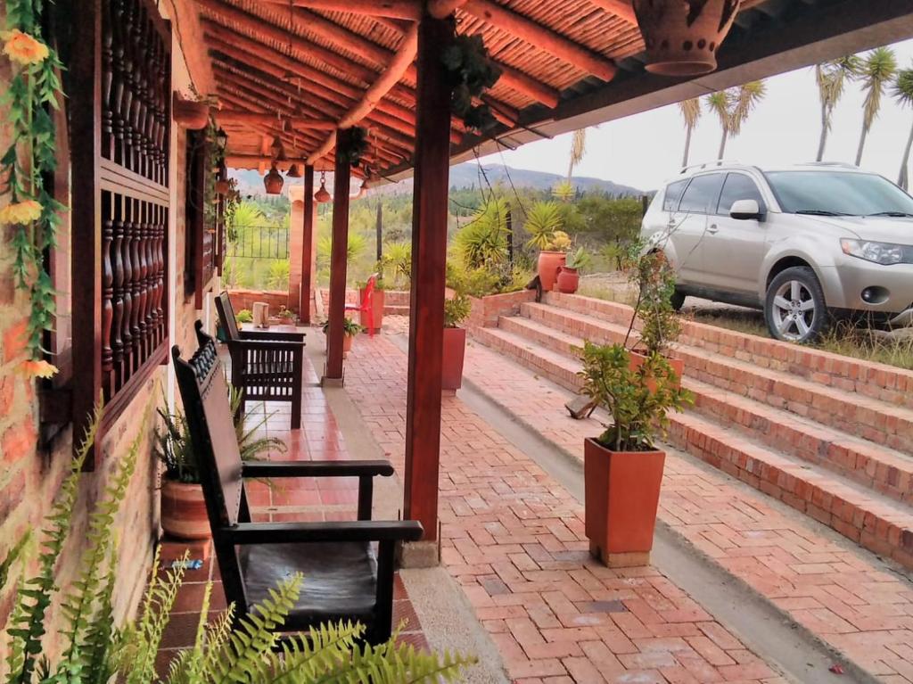 eine Terrasse mit einem Auto, das an der Seite eines Gebäudes geparkt ist in der Unterkunft CABAÑA RURAL SANTMARTIN in Sutamarchán