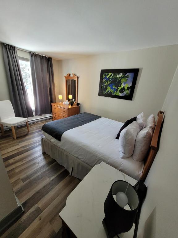 a hotel room with a large bed and a table at Oberge Inn Val-David in Val-David