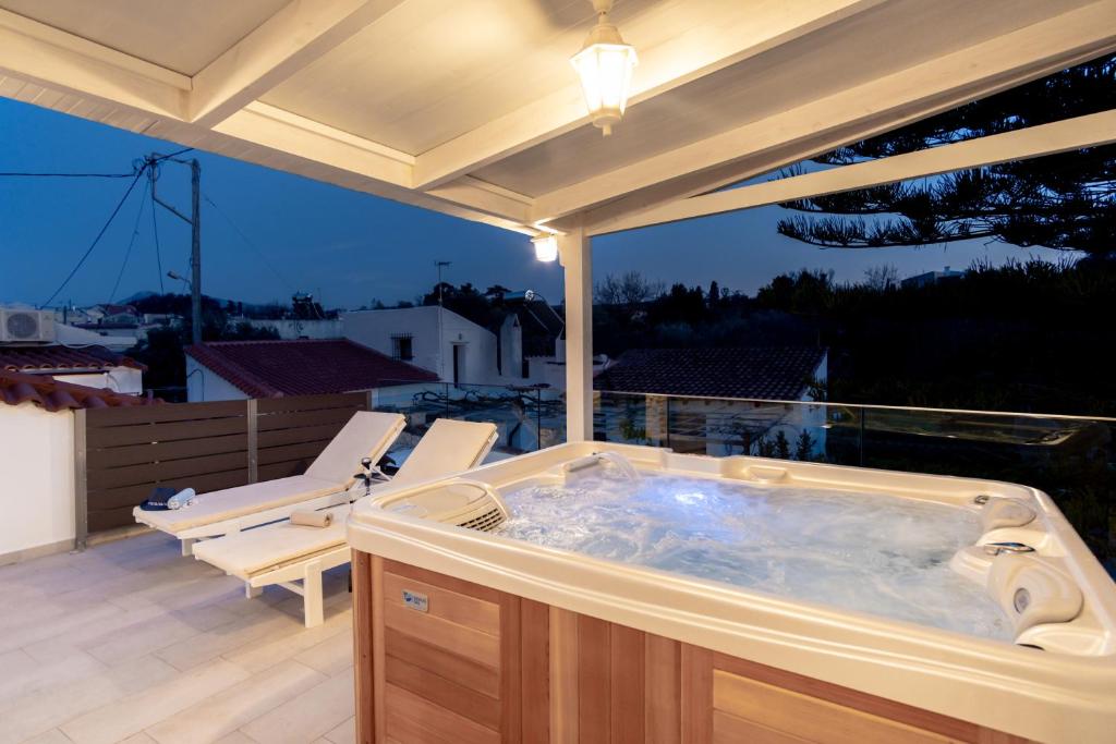 a hot tub sitting on a patio with a deck at Cozy Secret Home with Jetted Tub in Prinés