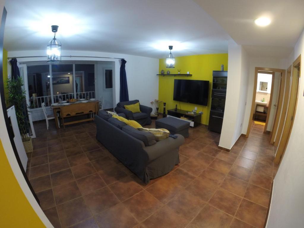 uma sala de estar com um sofá e uma televisão em Villa Sol em Corralejo