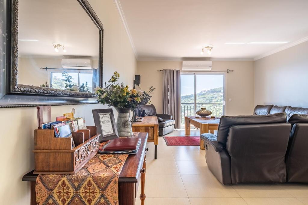 a living room with a couch and a table at Casa grata in Arco da Calheta