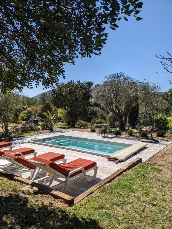 une piscine avec des chaises longues et une visière de piscine dans l'établissement Gite de l'Amandari - classé 3 etoiles Prefecture - piscine chauffée privative, terrasses et jardin, 5 minutes à pied du village, au Plan-de-la-Tour