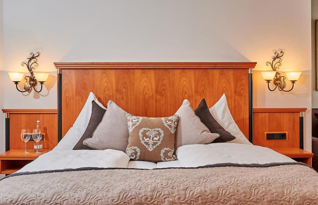 a large bed with a wooden headboard and pillows at Landhotel Schneider in Riedenburg