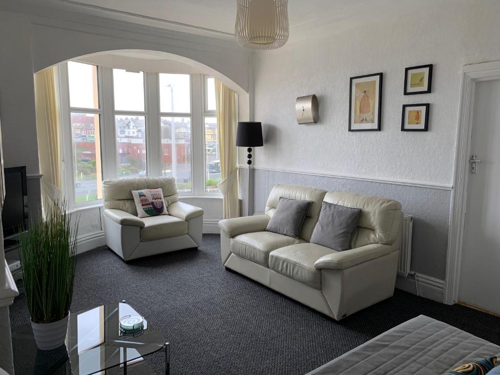 a living room with a couch and two chairs at Chateau Dale Holiday Apartments in Blackpool