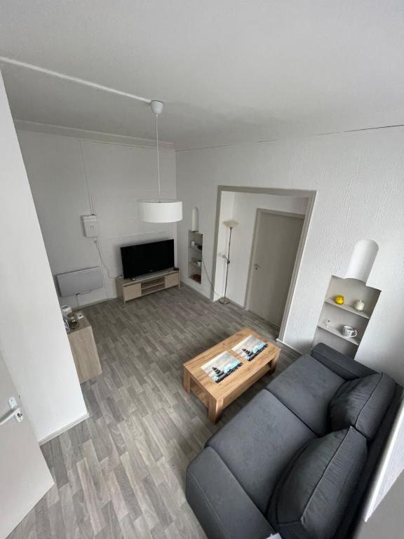 - un salon avec un canapé et une table dans l'établissement Superbe appartement rénové au centre de Forbach, à Forbach