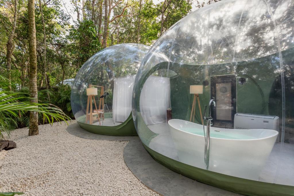 two glass domes with a tub in a garden at Oom Bubble Boutique Riviera Cancun in Puerto Morelos