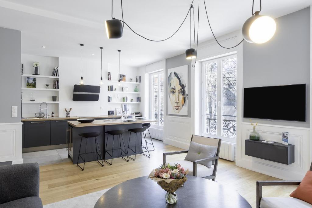 un salon avec une table et une cuisine dans l'établissement L'AUBELYNE - Chic T2 quartier préfecture, à Lyon