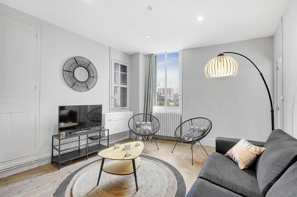 a living room with a couch and a table at L'APOLLINAIRE - à 5 minutes du centre ville in Toulouse