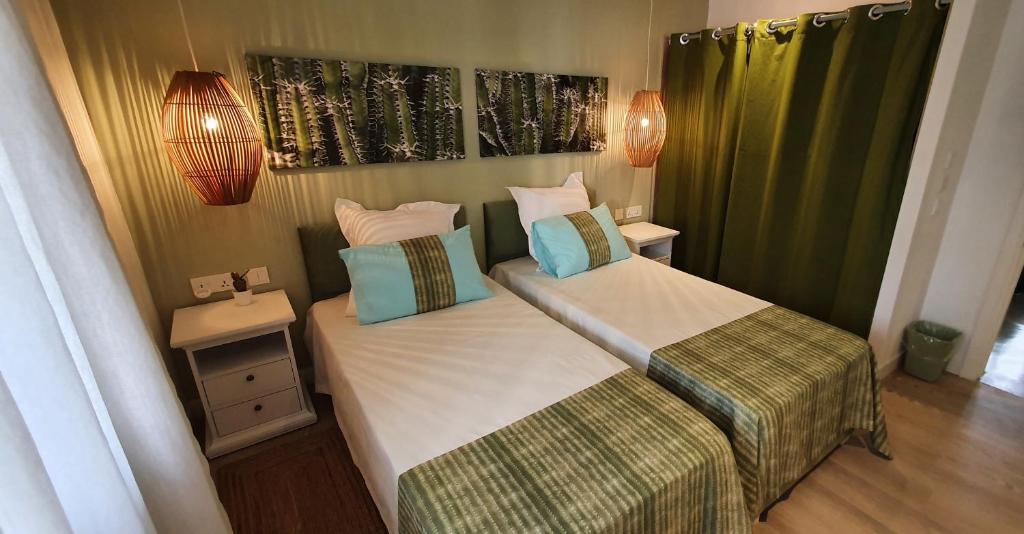 ein kleines Schlafzimmer mit 2 Betten und 2 Lampen in der Unterkunft Les Cerisiers - Exclusive Beach Residence - 3 Bedroom Modern Apartment, Flic en Flac in Flic-en-Flac