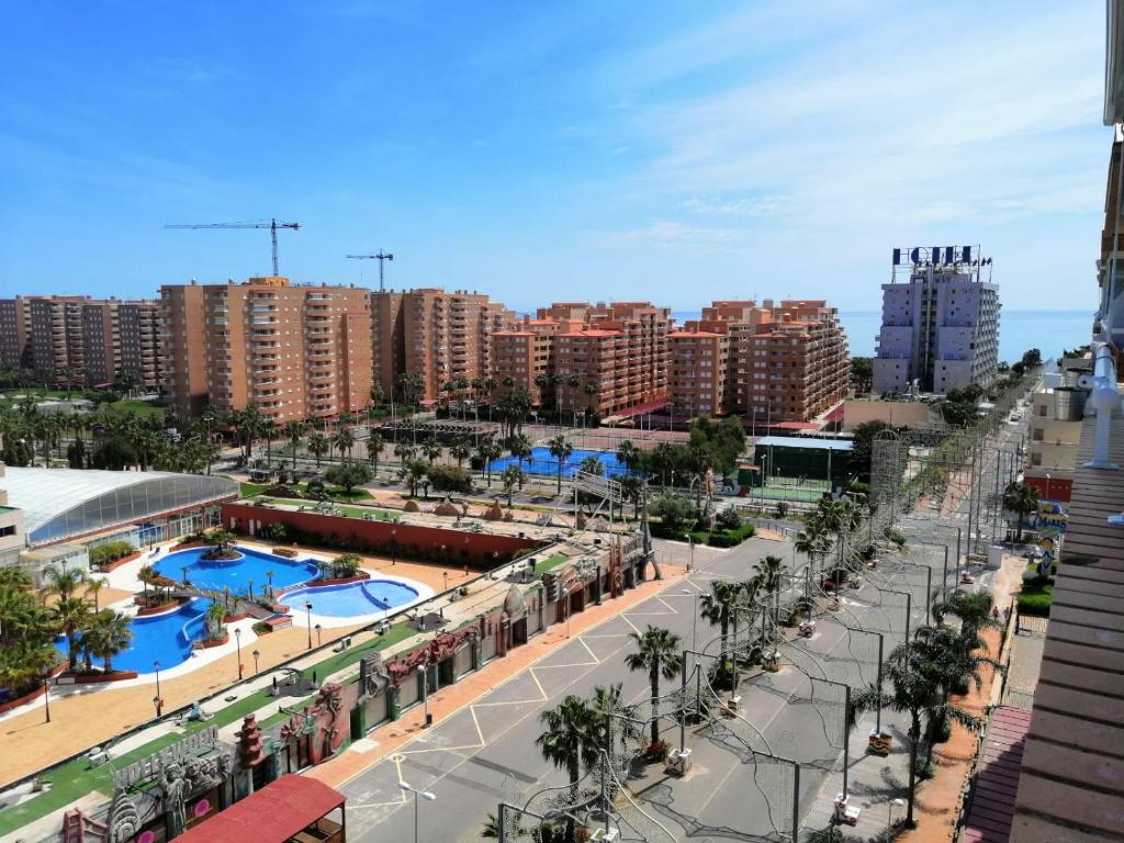 una calle de la ciudad con palmeras y piscinas en APCOSTAS Marina D'or 2da Línea, en Oropesa del Mar