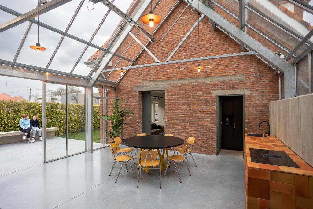 a patio with a table and chairs in a brick building at stek&stoof in Sint-Pauwels