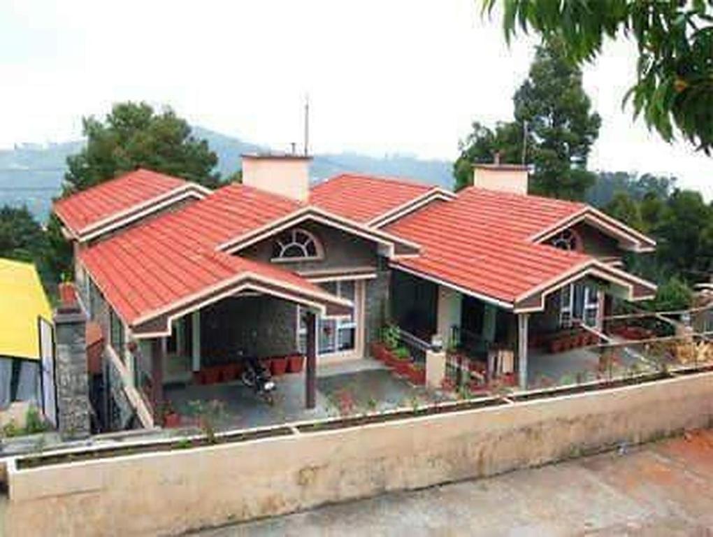 a house with red roofs on top of a street at Kumaragiri Cottages Kodaikanal in Kodaikānāl