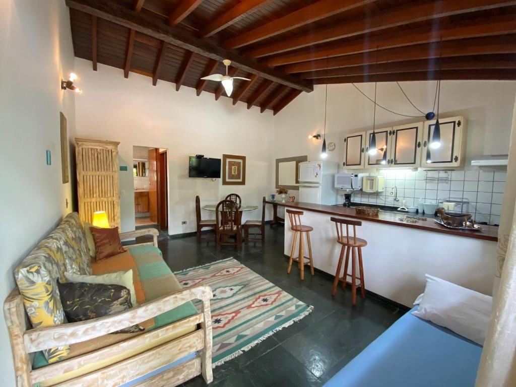 a living room with a couch and a kitchen at Casa Vento Norte in Ilhabela
