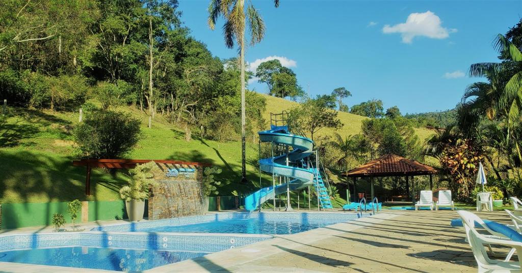uma piscina com um escorrega de água azul em Pousada da Cachoeira em Monte Alegre do Sul