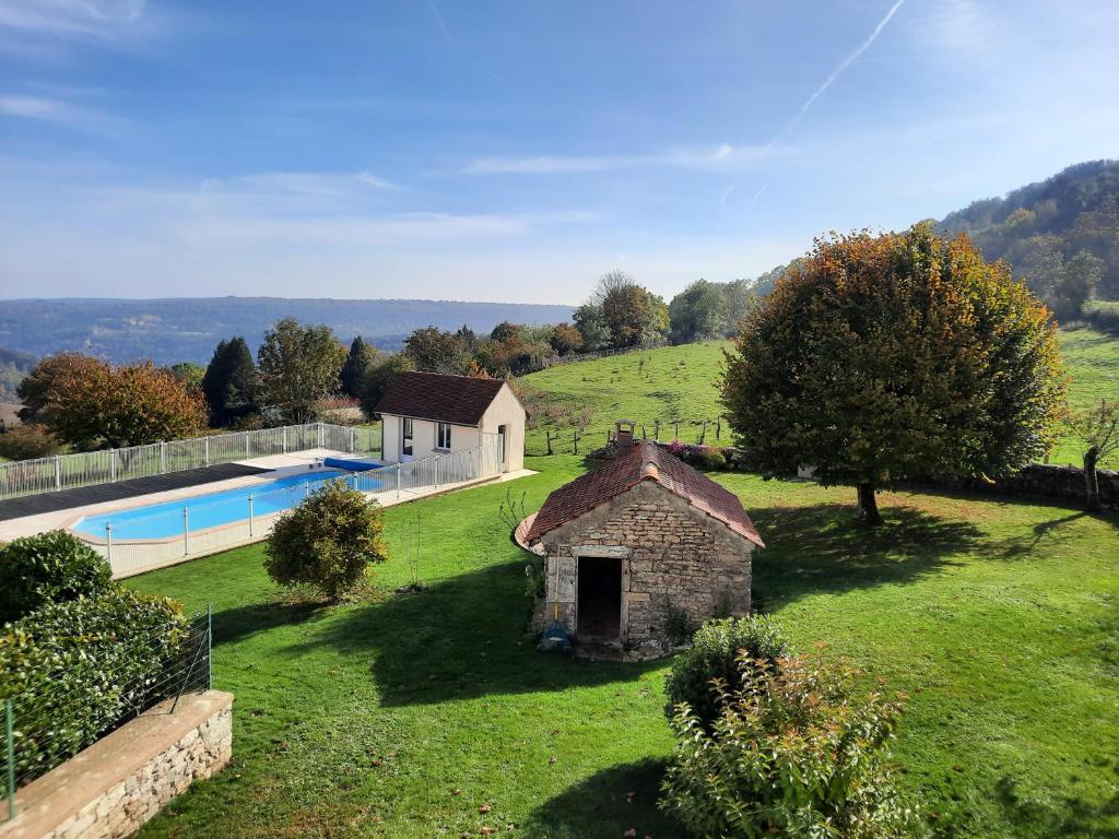 una antigua casa de piedra en un campo con piscina en Au dela des vignes, en Baubigny