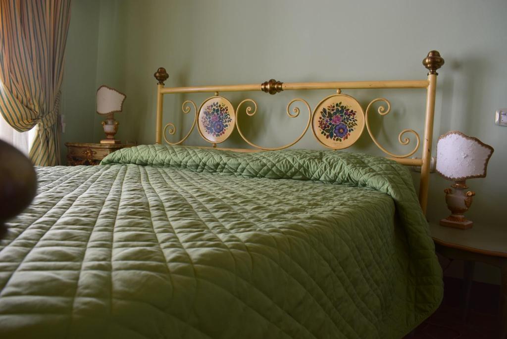 a bedroom with a bed with a green comforter at Appartamento Baldo 13 in Perugia