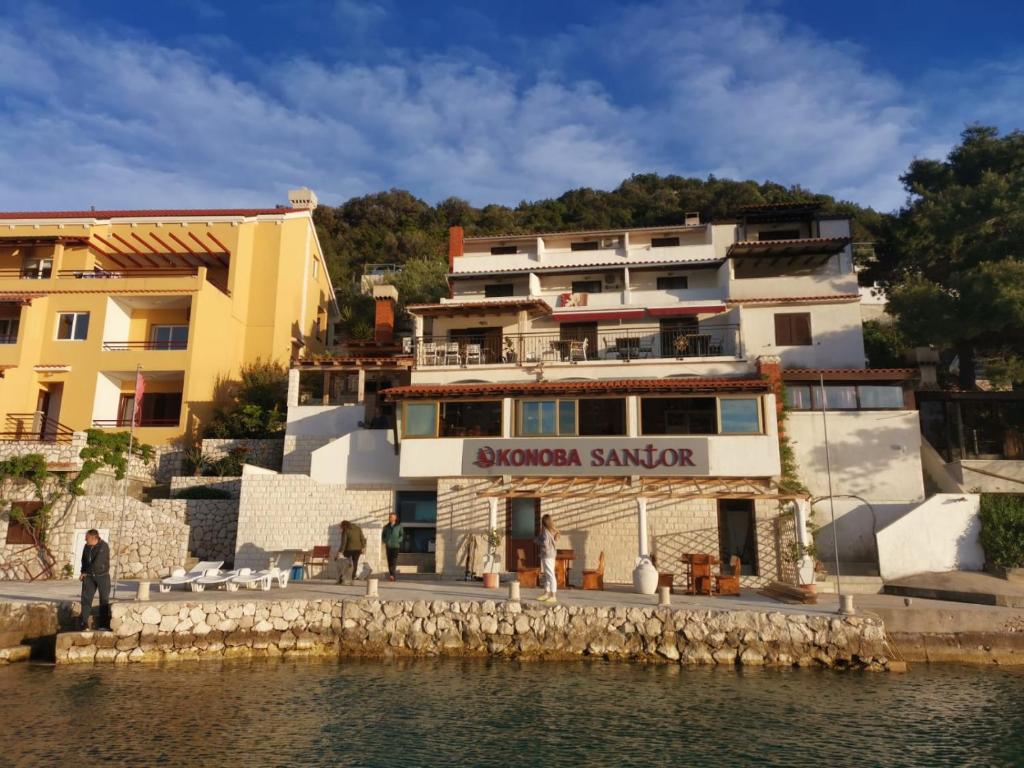 eine Gruppe von Gebäuden neben einem Wasserkörper in der Unterkunft Guesthouse Santor in Lastovo