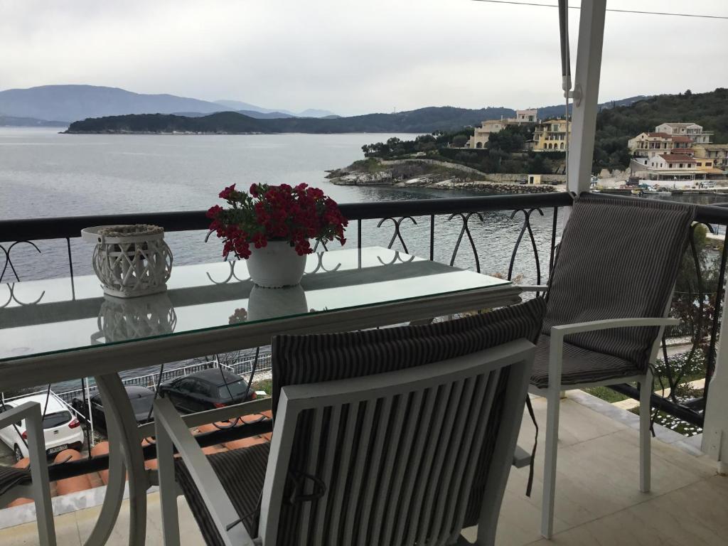 a table and chairs on a balcony with a view of the water at Corfu island apartment in KASSIOPI by seaside in Kassiopi