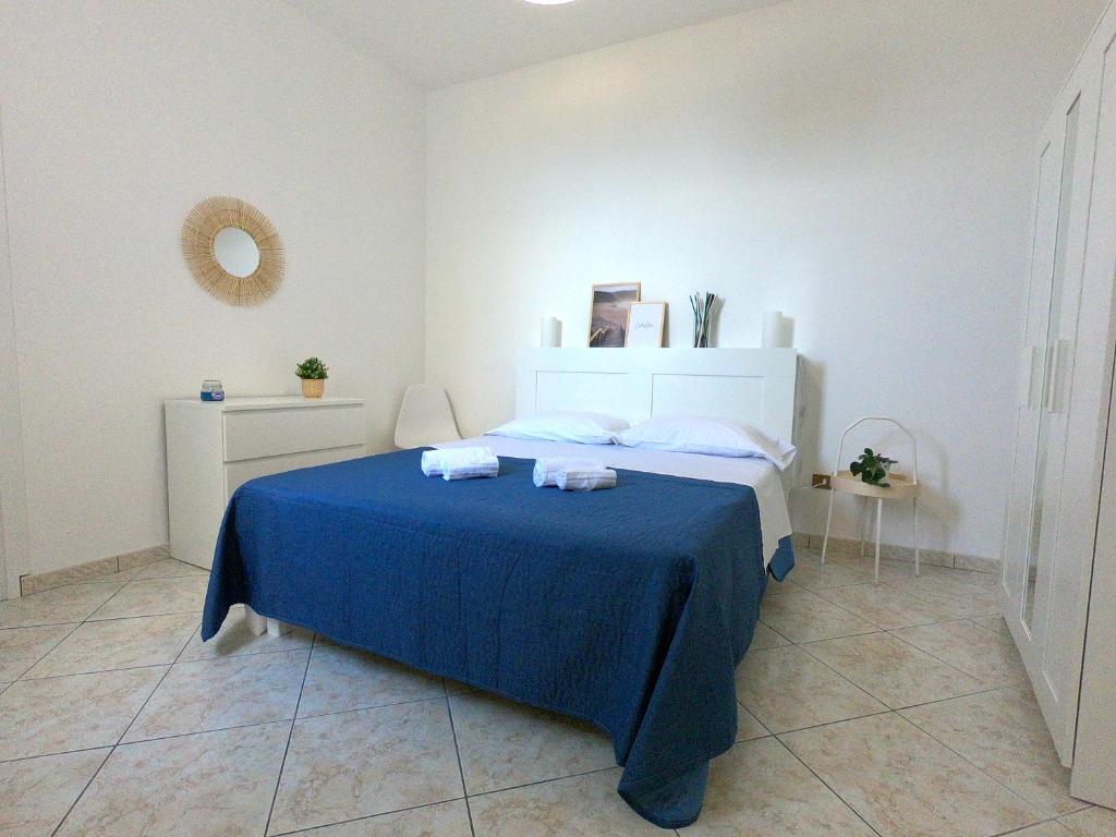 um quarto com uma cama com um cobertor azul em La Casetta sul Golfo em Sferracavallo