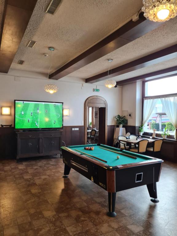 a living room with a pool table and a flat screen tv at Zappa Lake Lodge in Brusino Arsizio