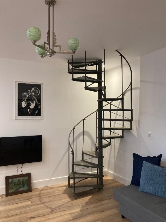 - un escalier en colimaçon dans le salon doté d'un canapé dans l'établissement JAZZ - Appart original 5pers rdch arrière cour calme, à Mulhouse