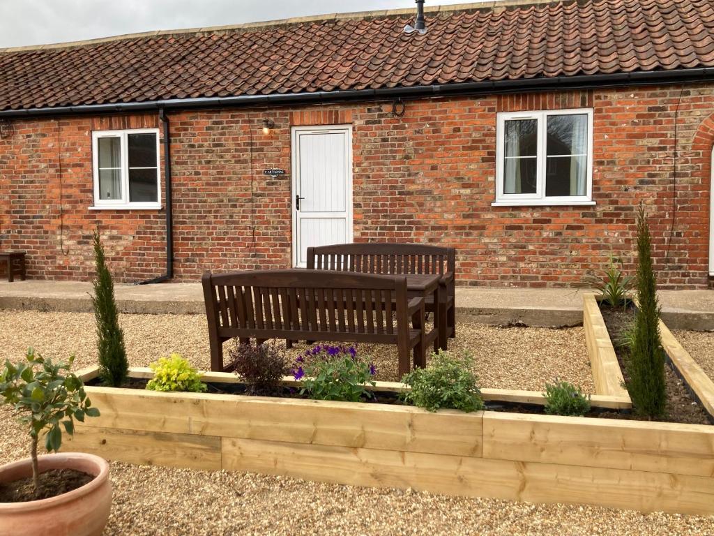 a bench sitting in front of a brick house at Martinmas Cottage in Flamborough